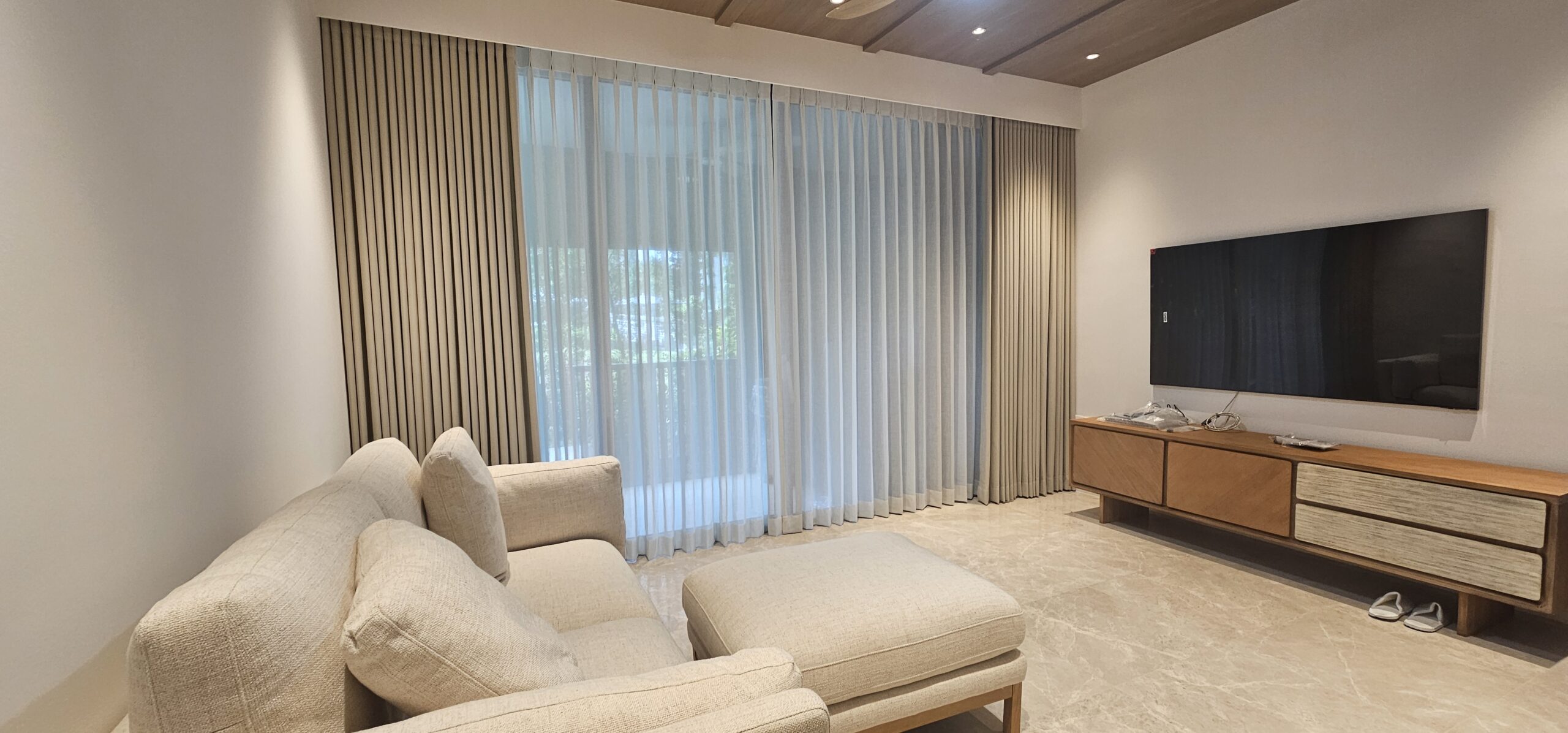 Shaped Ripple-Fold night curtains paired with Double Pleated sheer day curtains across a wide living room window