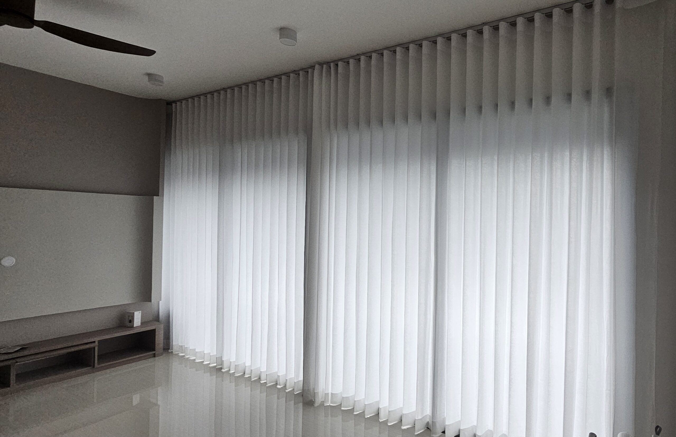 Full-height ripple fold sheer day curtains with consistent waves across a wide window