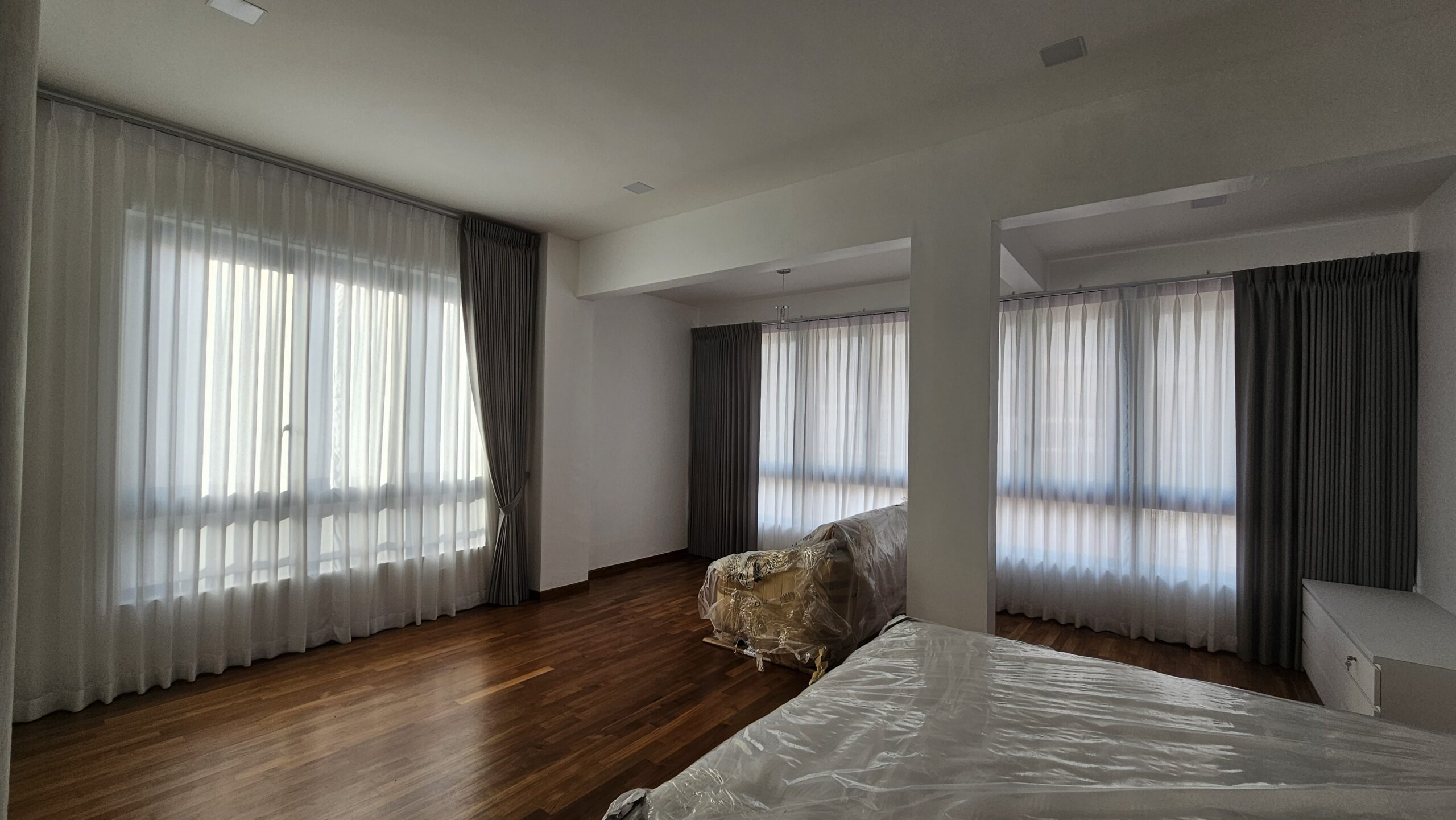 Shaped double pleat night curtains with sheer day curtains across multiple windows