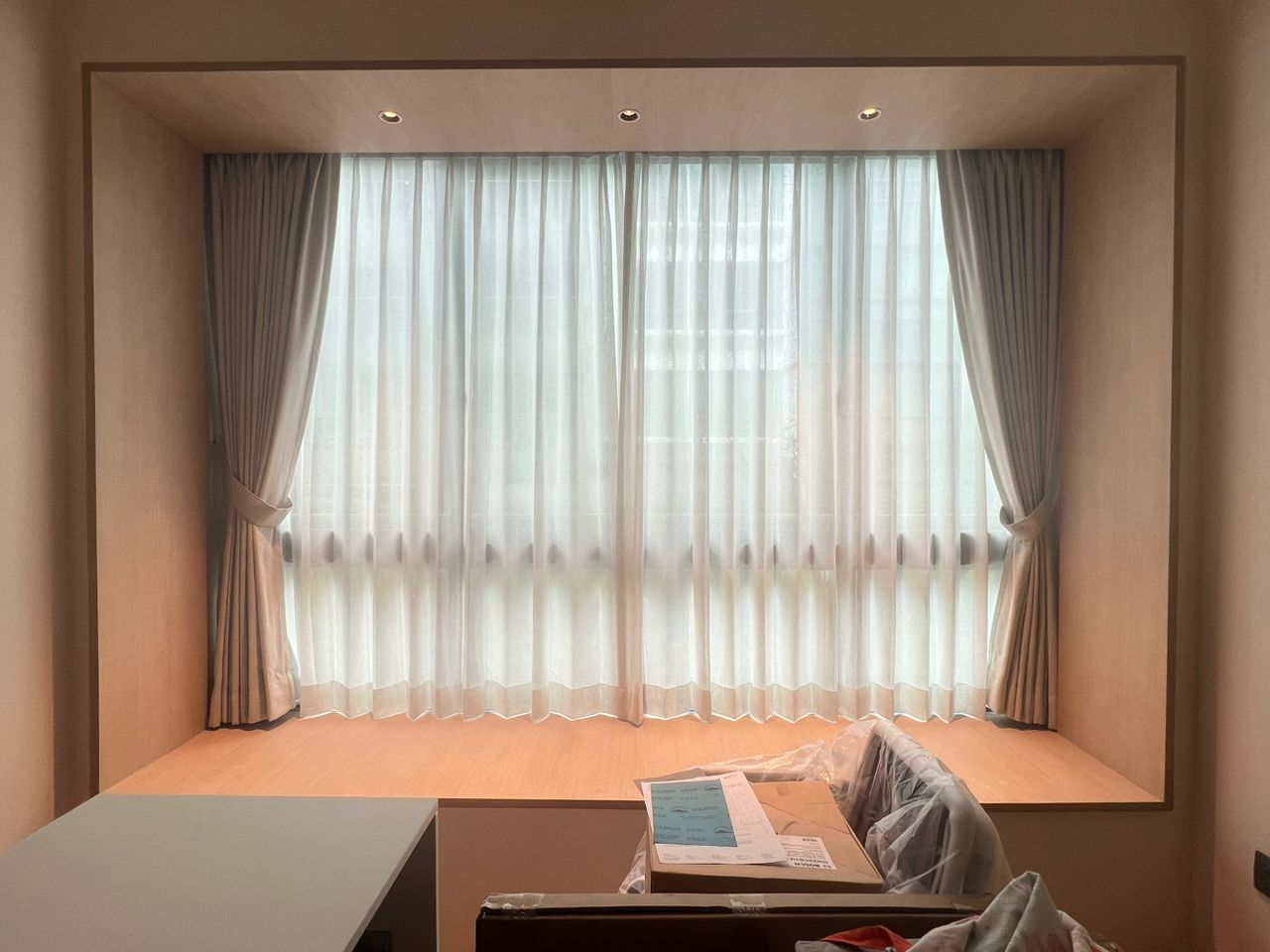 Shaped day and night curtains framing a recessed window seat