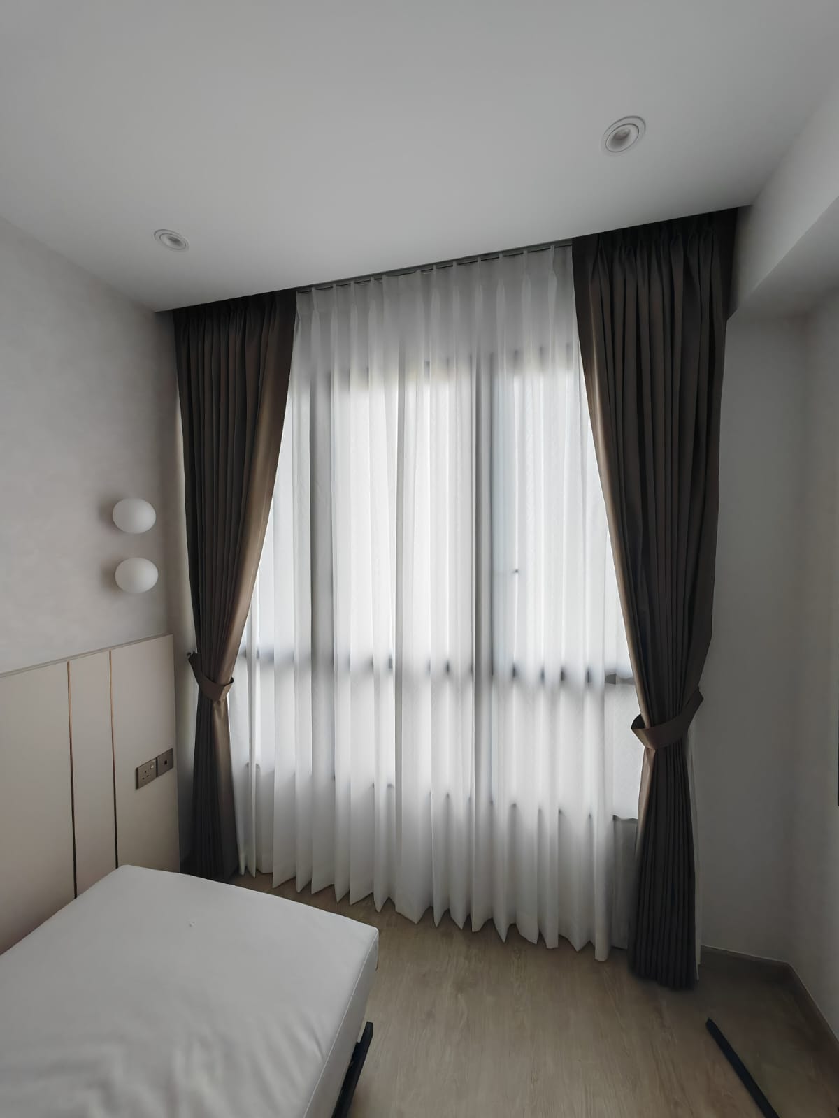 Shaped double pleat night curtains framing privacy sheer day curtains across a bedroom window