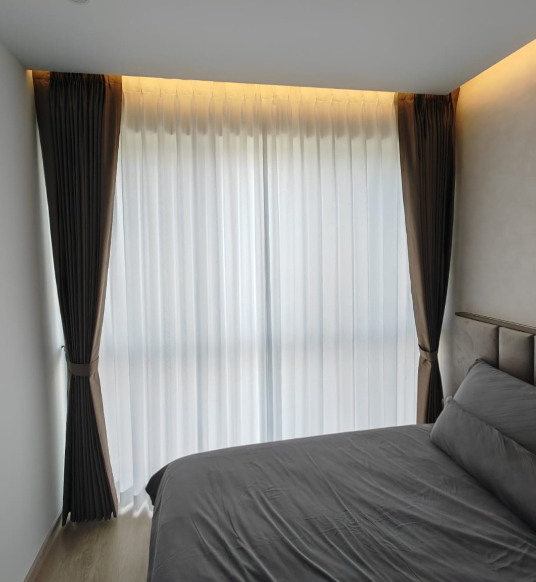 Full-height shaped night curtains paired with privacy sheer day curtains in a bedroom