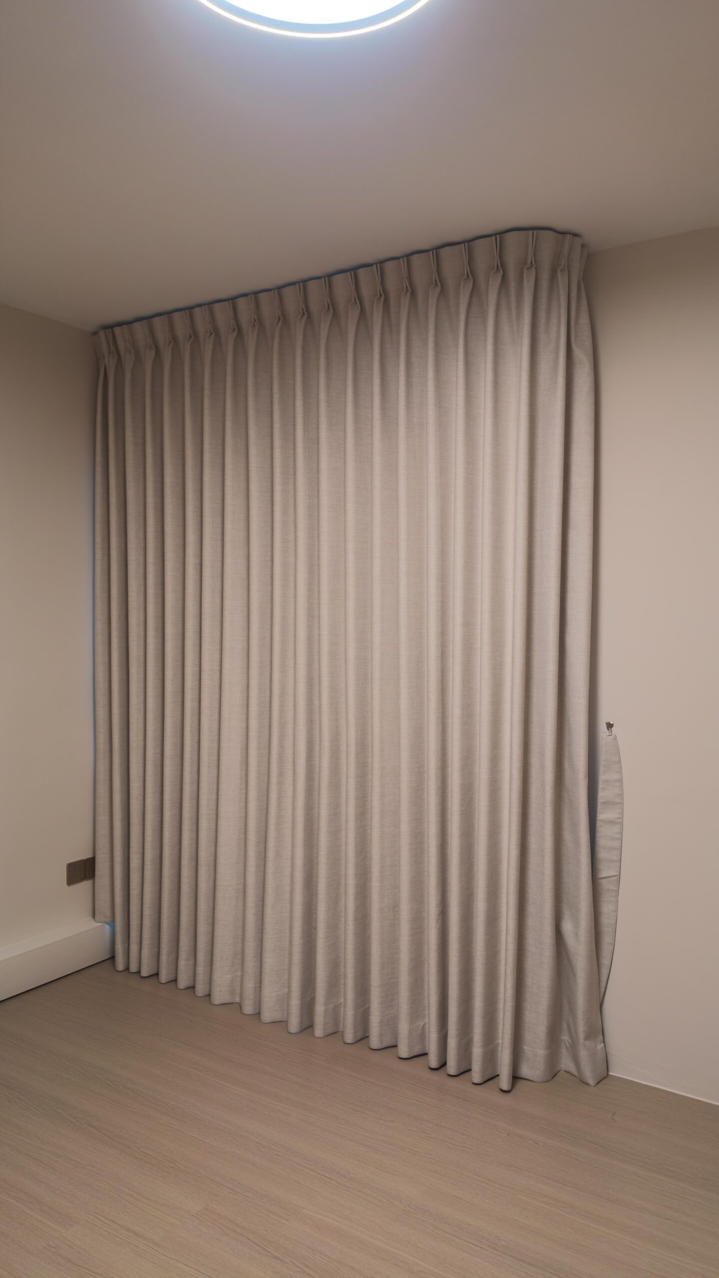 Closed double pleat Blackout curtains with consistent shaped folds across a bedroom window