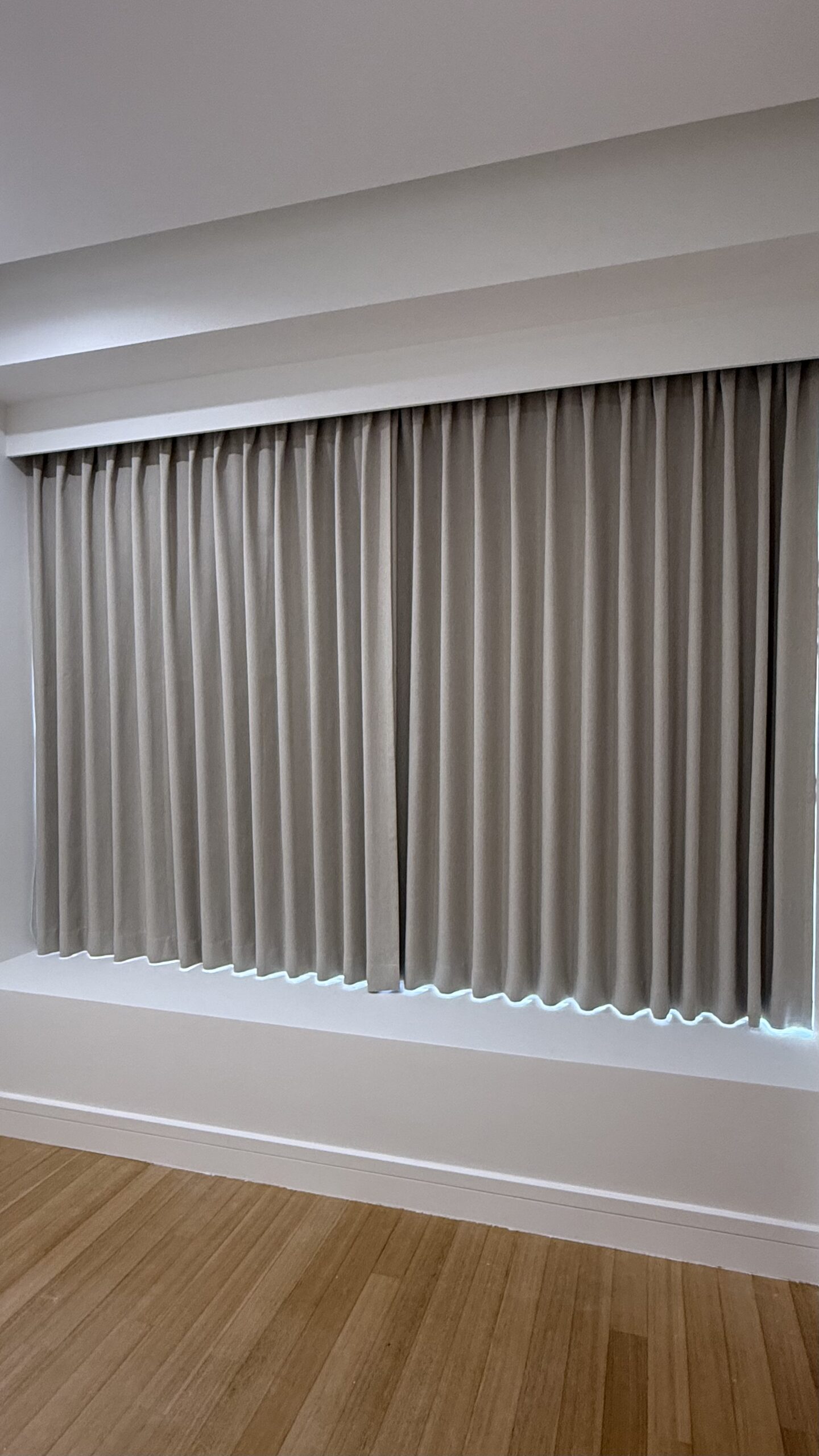 Dim-Out curtains with consistent shaped folds installed beneath a recessed track